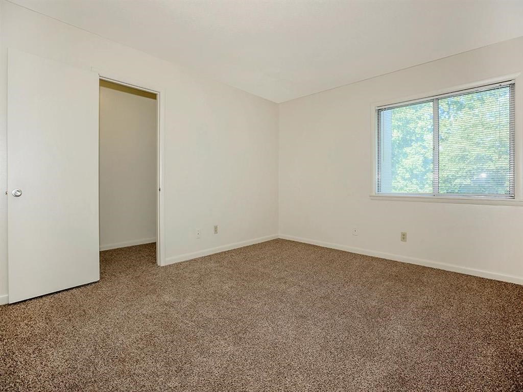 an empty room with carpet and a window