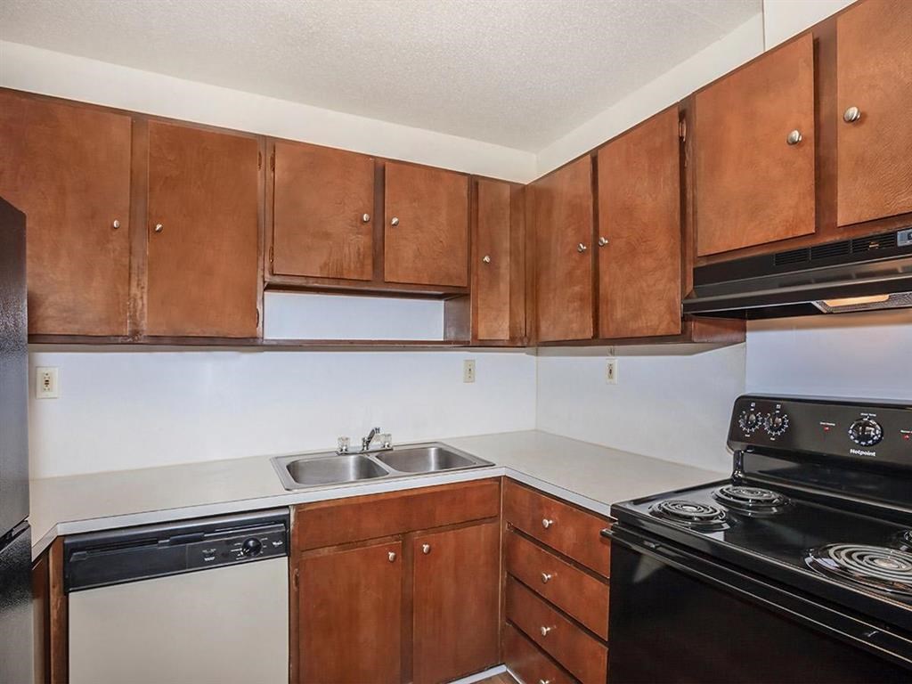 a kitchen with wooden cabinets and a stove and a sink