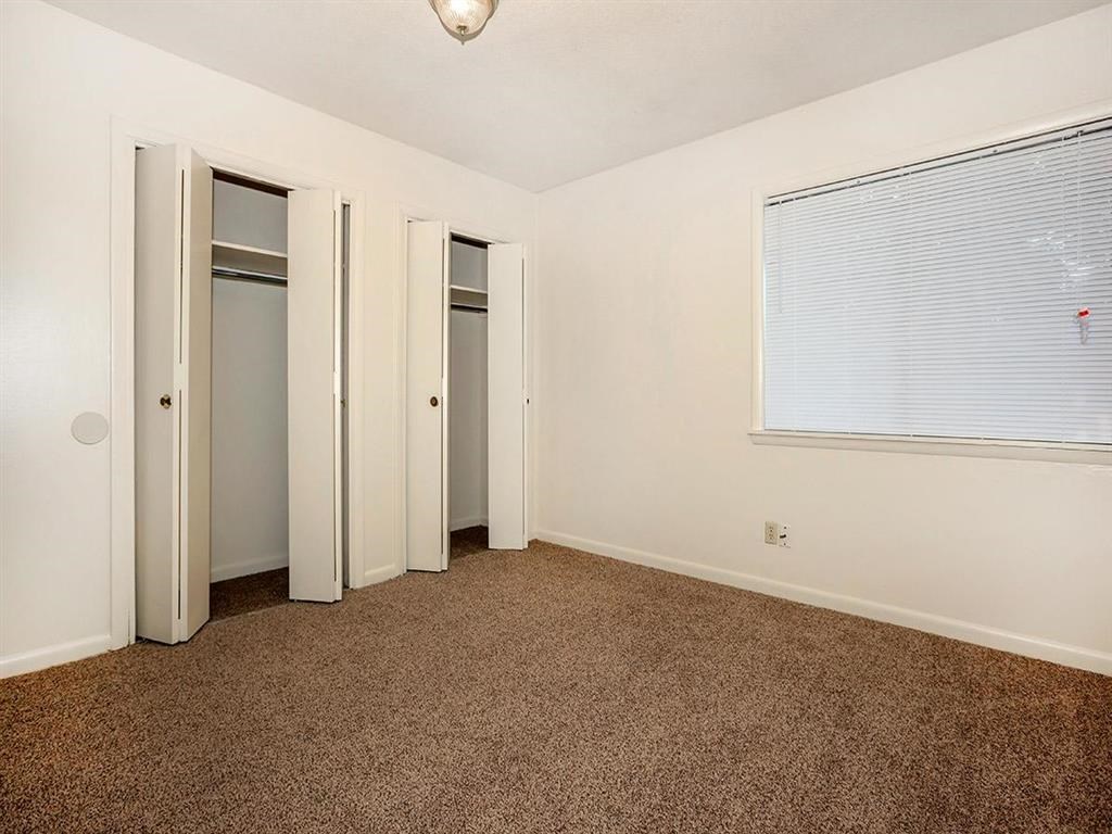 an empty room with a window and three doors