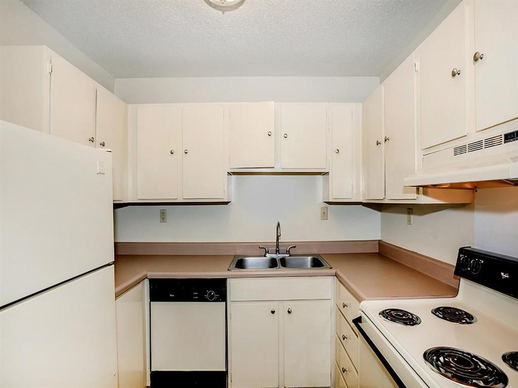 a kitchen with white cabinets and a stove and a sink
