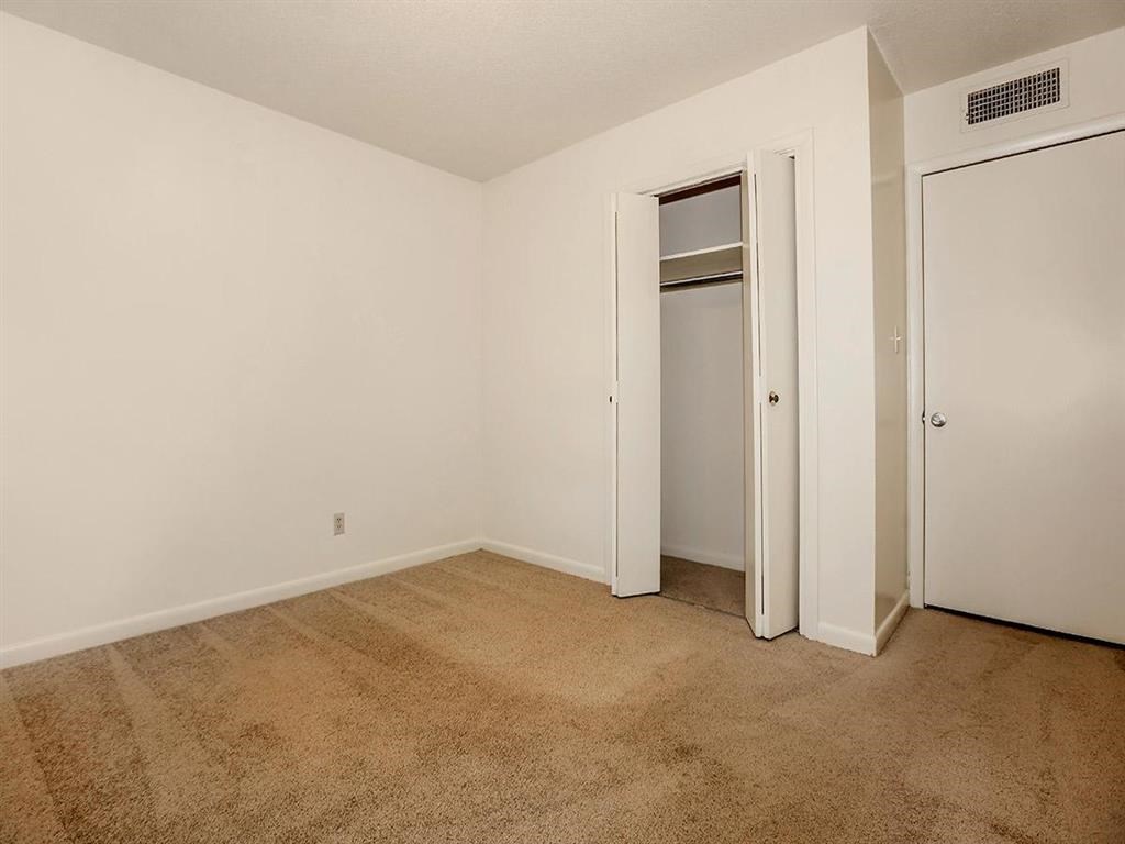 a room with a carpeted floor and a closet