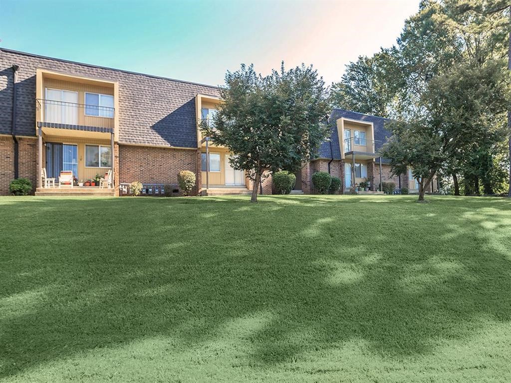 a large lawn in front of a brick building