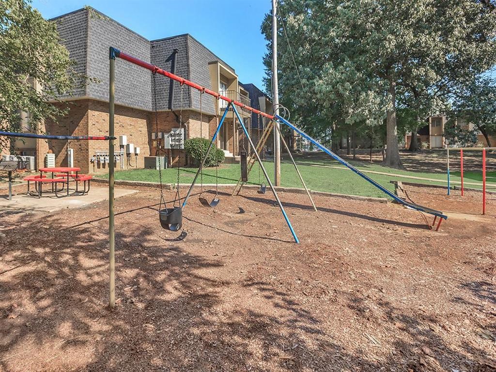 a swing set in a playground in front of a building