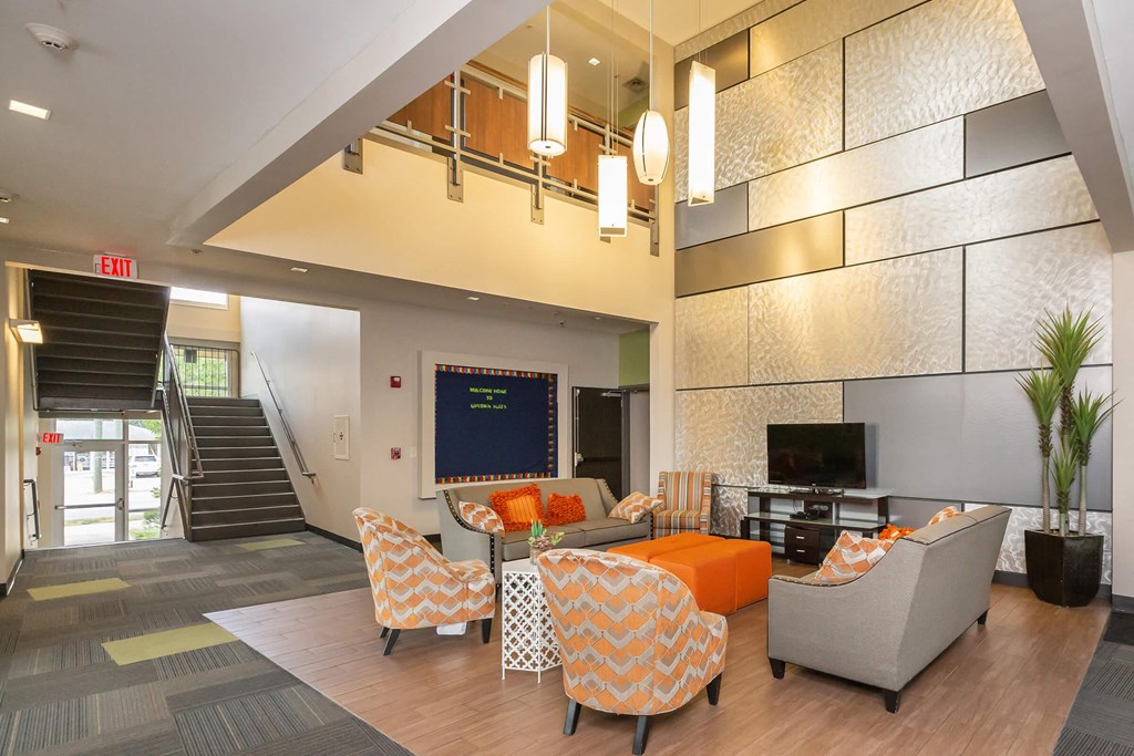a lobby with couches and chairs and a tv
