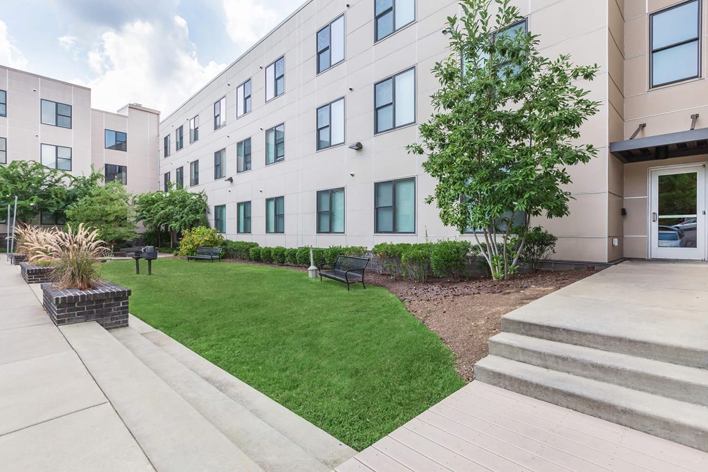 an exterior view of an apartment building with a lawn and grass