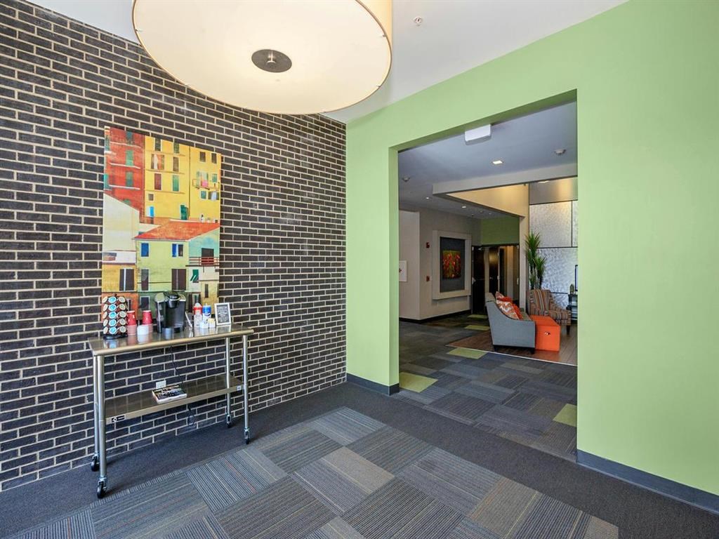 a lobby with a table and a brick wall