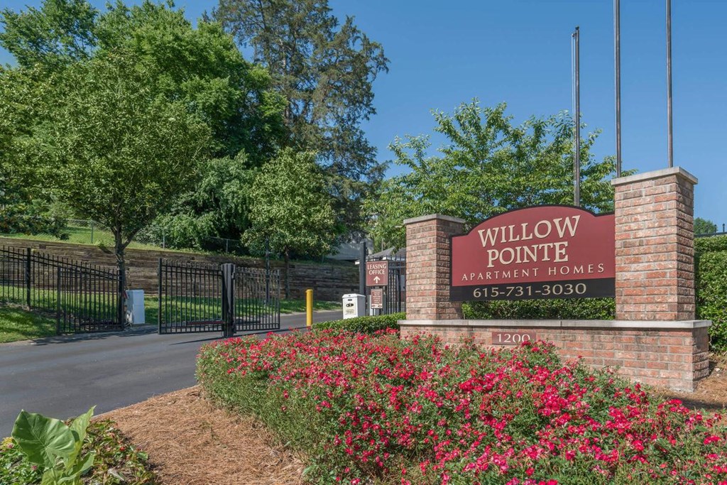 a sign for willow pointe apartment homes in front of a gate