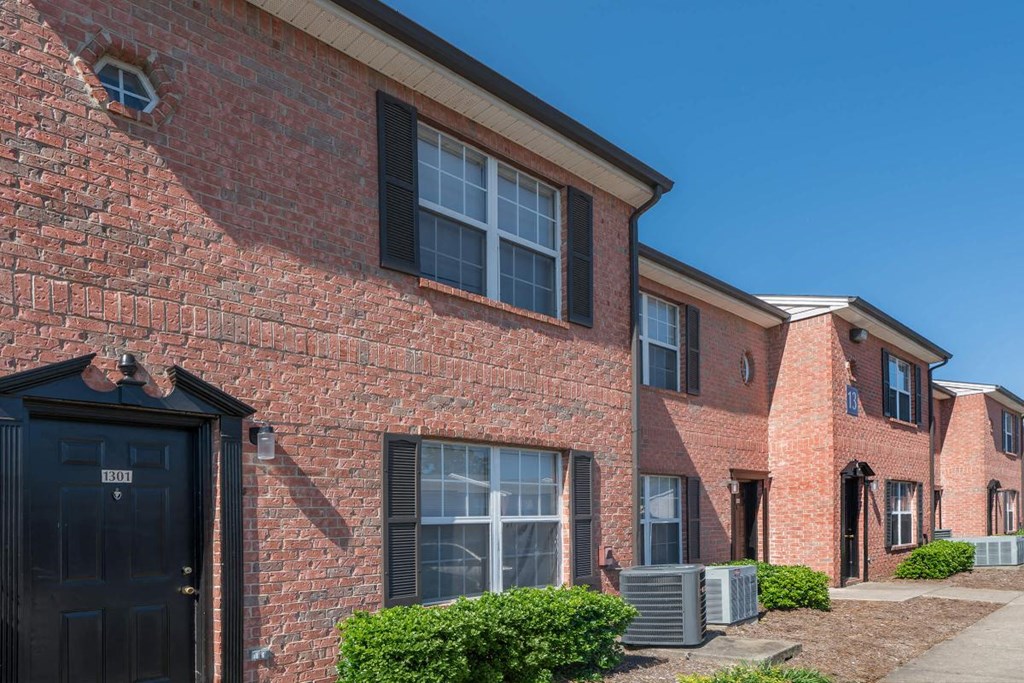 a brick apartment building with black doors and windows