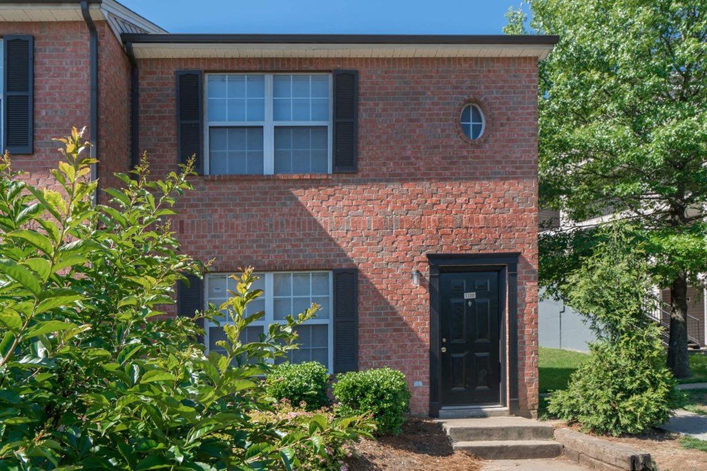 a red brick house with a black door and black windows