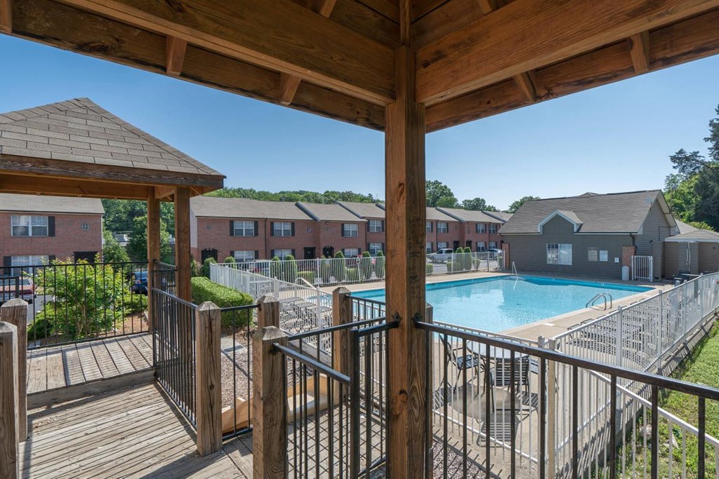 a view of a swimming pool from a deck with a fence