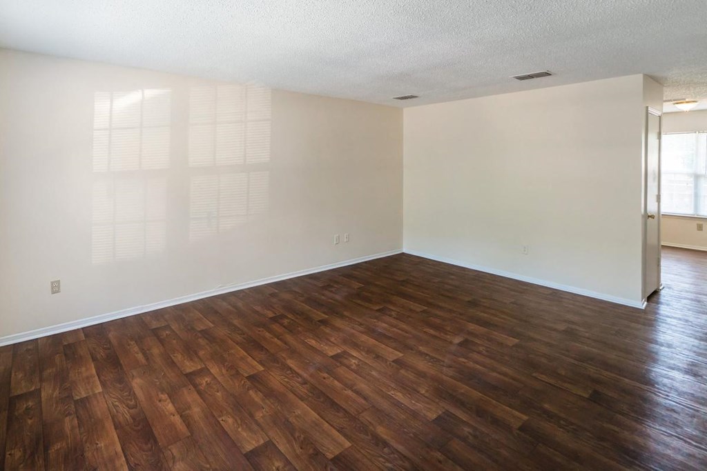 an empty living room with a hard wood floor