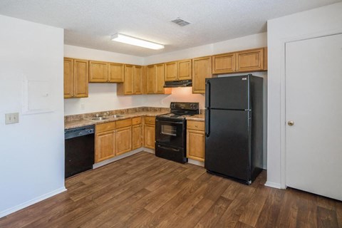 a kitchen with wooden cabinets and a black refrigerator