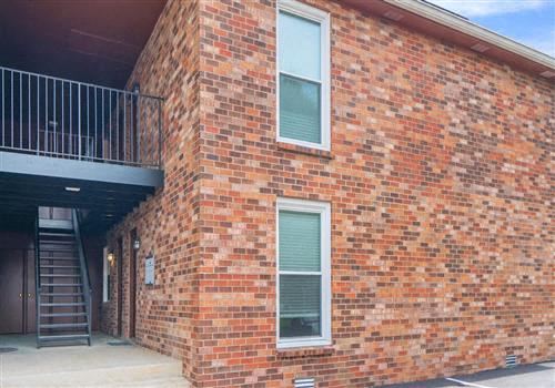 a brick building with a balcony and a staircase