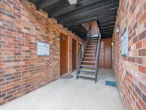 an empty brick building with a staircase and a brick wall