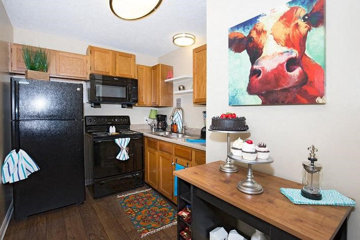 a kitchen with a table and a painting of a cow