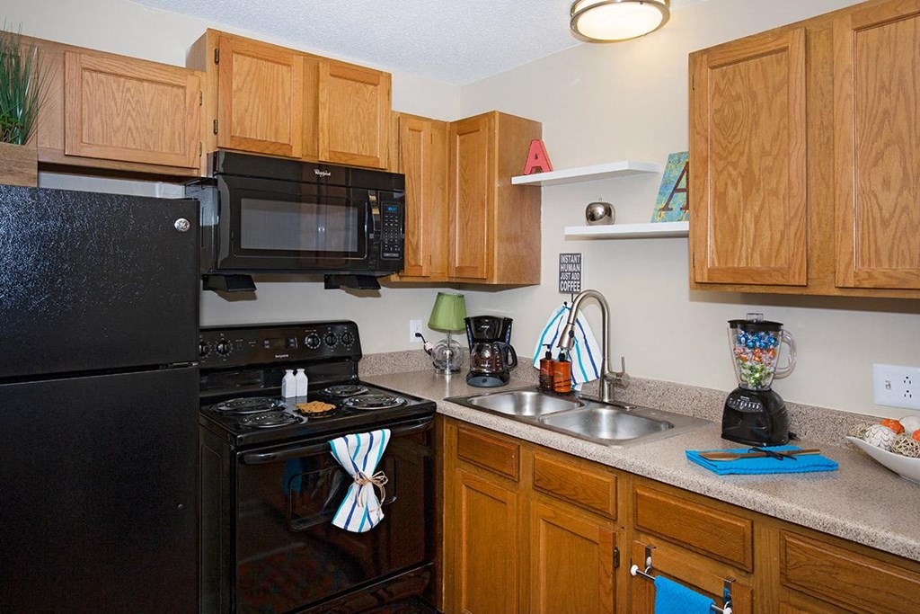 a kitchen with black appliances and wooden cabinets