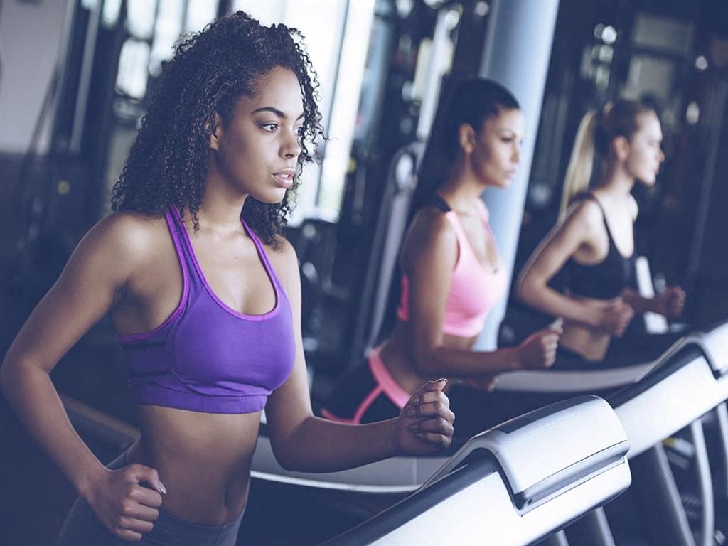a group of women running on a treadmill at the gym