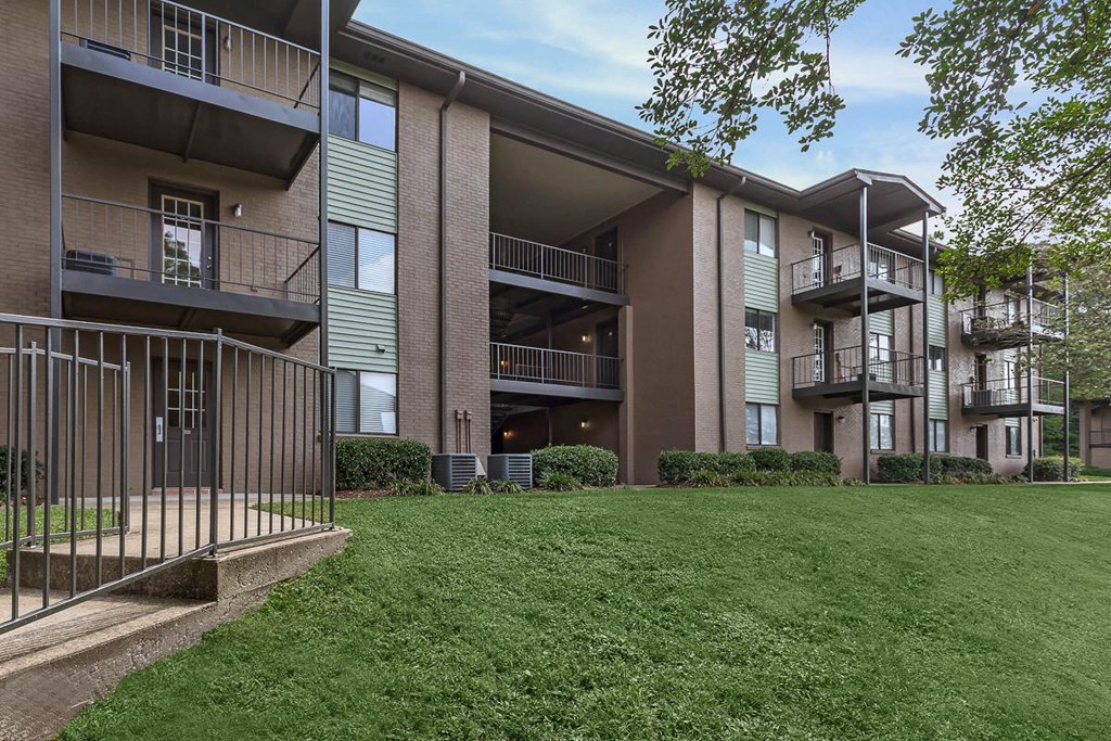 the outlook of an apartment building with a green lawn
