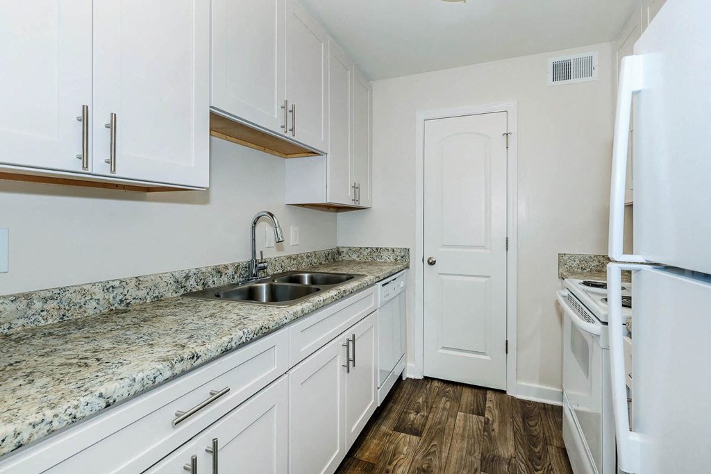 a kitchen with white cabinets and a sink and a refrigerator