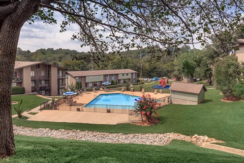 an aerial view of a swimming pool with apartments in the background