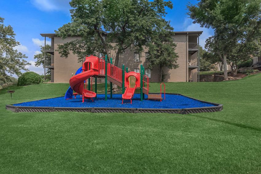a playground in a yard with a building in the background
