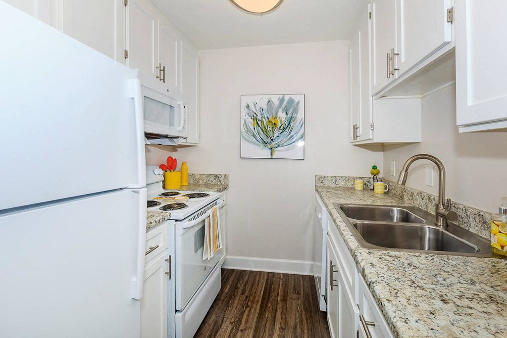 a kitchen with white appliances and granite counter tops