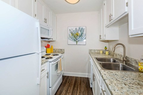 a kitchen with white appliances and granite counter tops