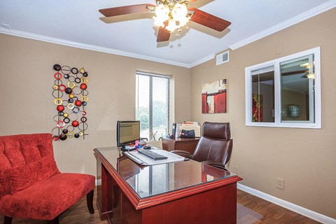 a living room with a desk and a chair