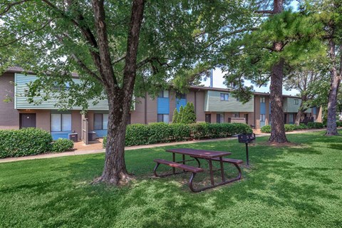 a picnic table sitting in the grass near some trees