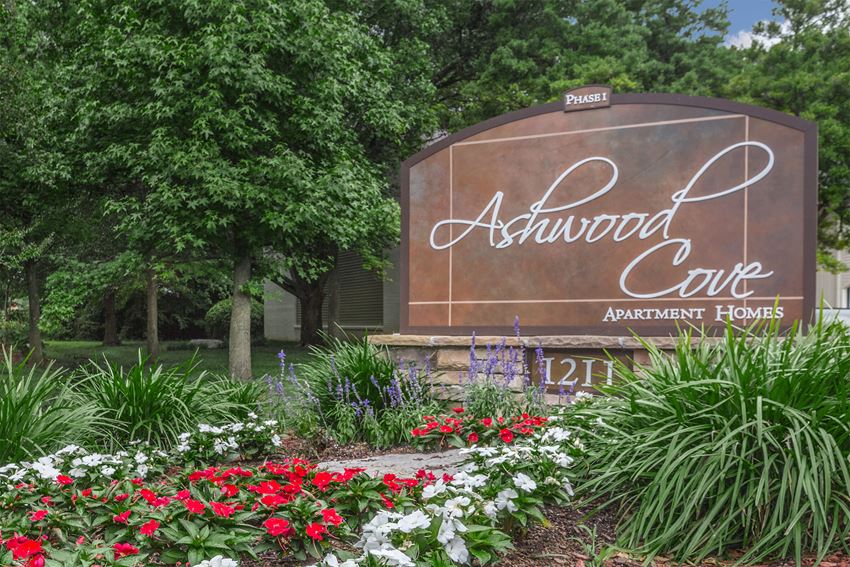 a sign for the ashwood cafe with flowers in front of it
