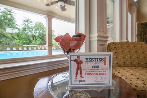 a sign sitting on a table in a living room with a window