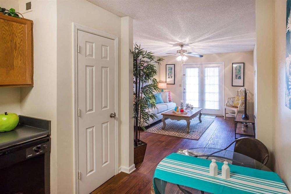 a view of a living room and a kitchen with a surfboard