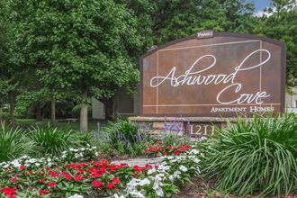 a sign for the ashwood cafe with flowers in front of it