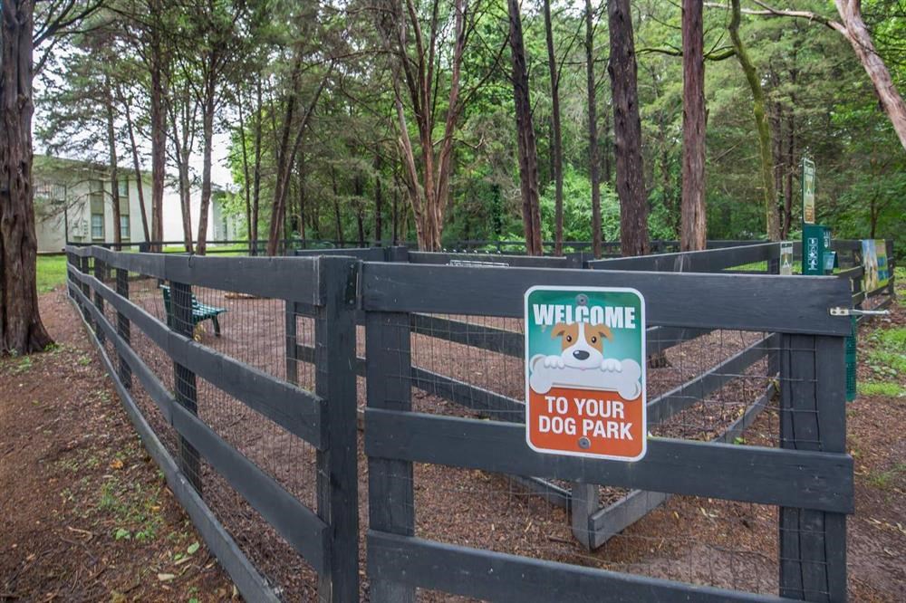 a sign on a fence in a dog park