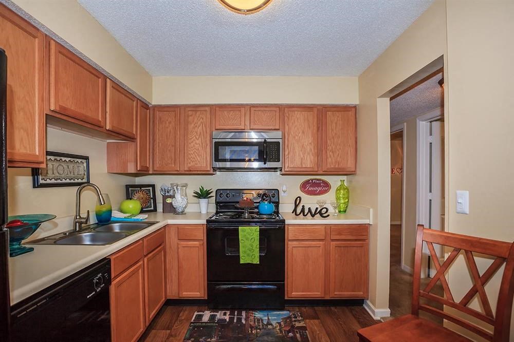 a kitchen with black appliances and wooden cabinets