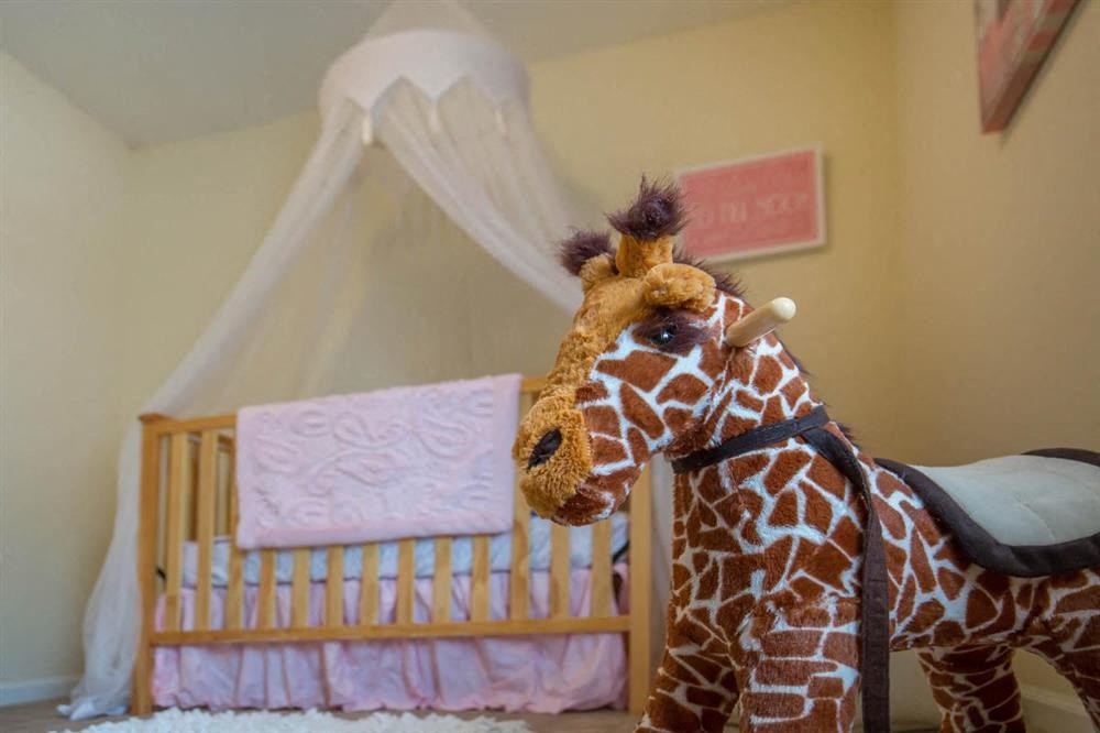 a stuffed giraffe in a nursery with a crib