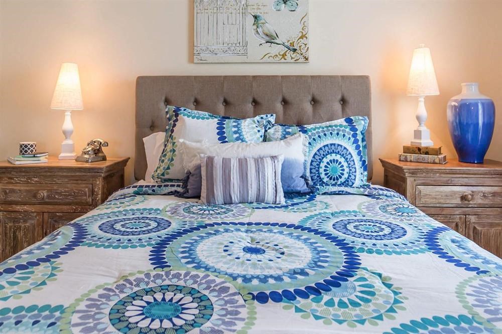 a bedroom with a bed with a blue and white comforter