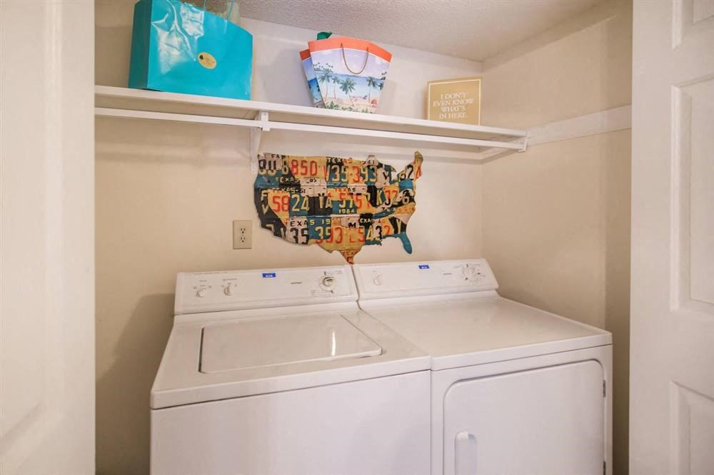 a white laundry room with a washer and a dryer