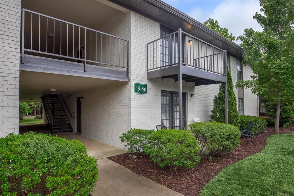 a sidewalk in front of a building with a balcony