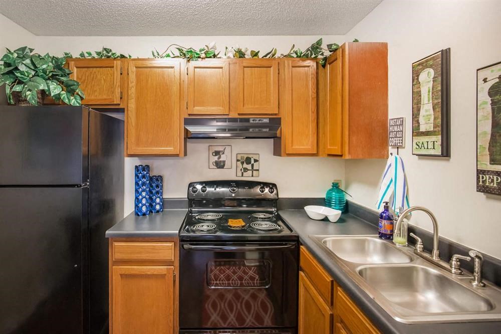 a kitchen with a stove refrigerator and sink