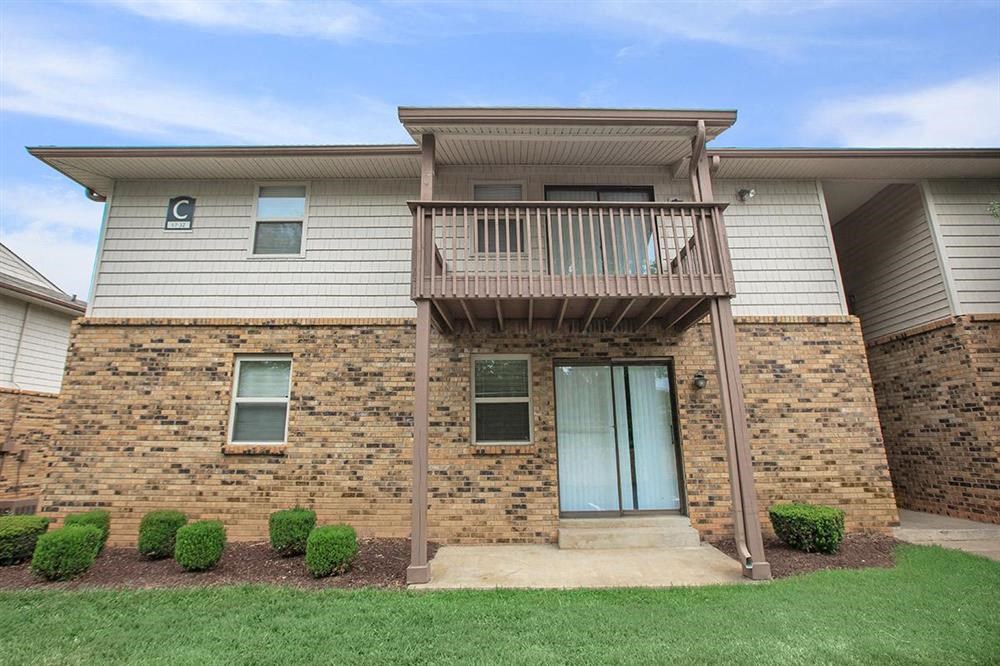 the front of a brick house with a balcony