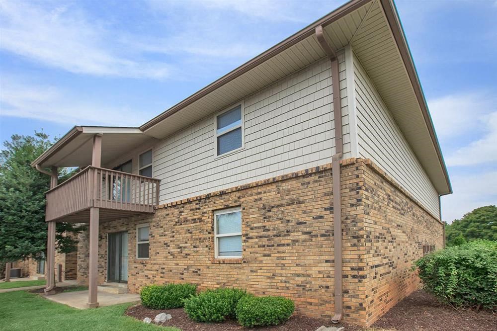 a house with a balcony and a brick wall