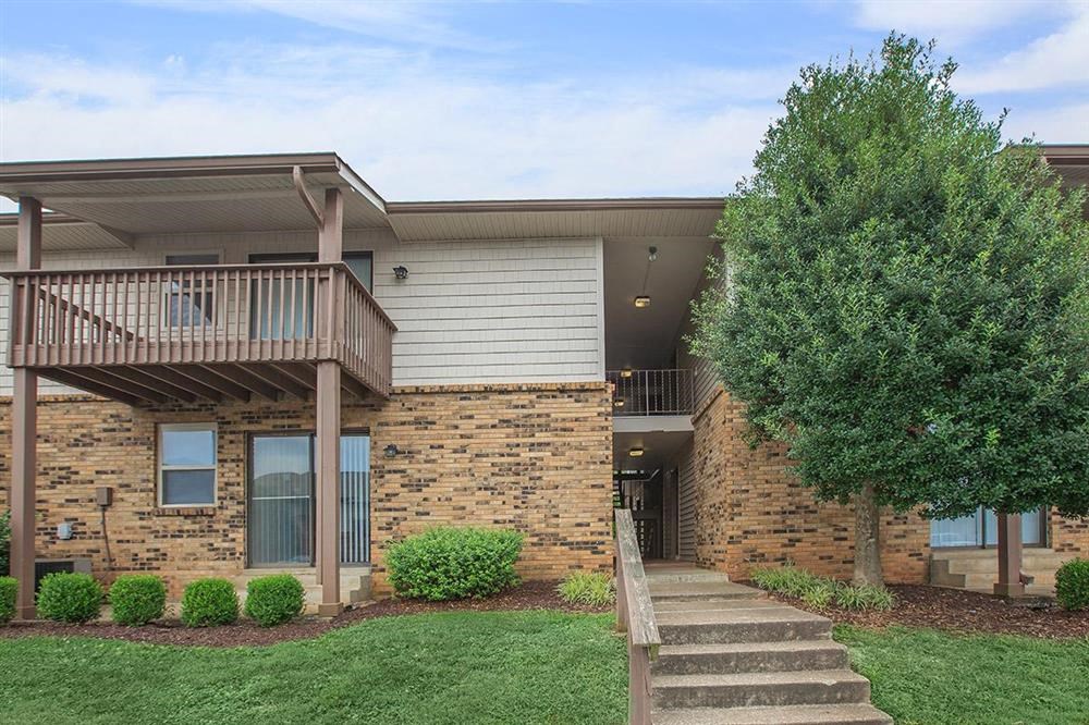 a building with stairs and a tree in front of it