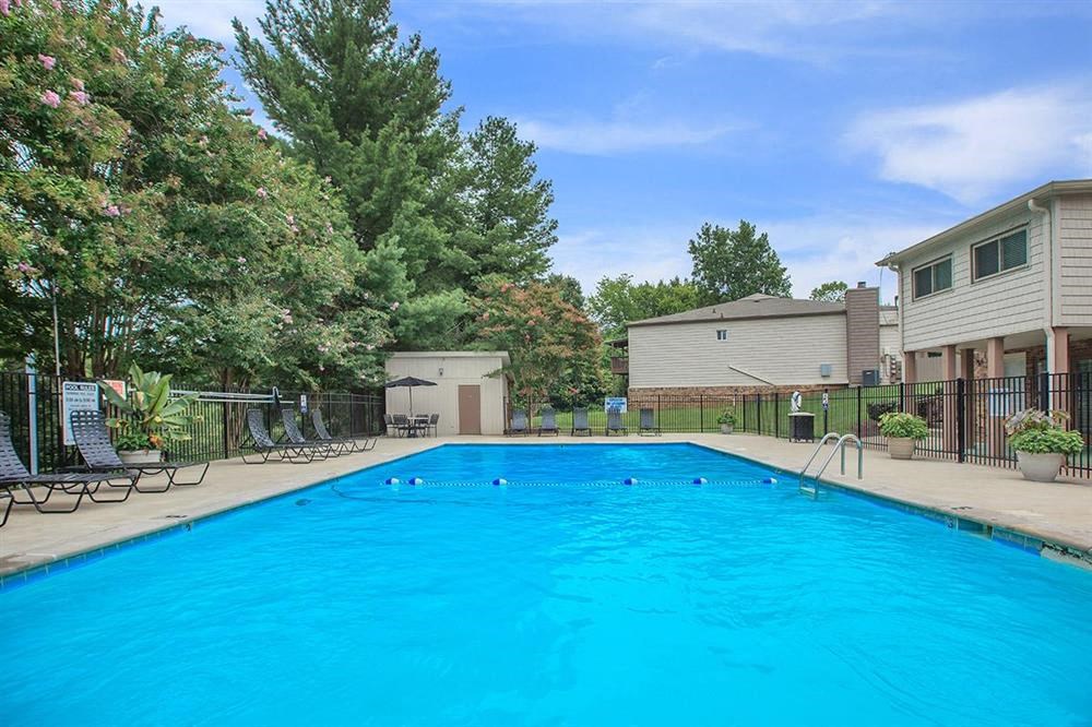 a large blue swimming pool in front of a house