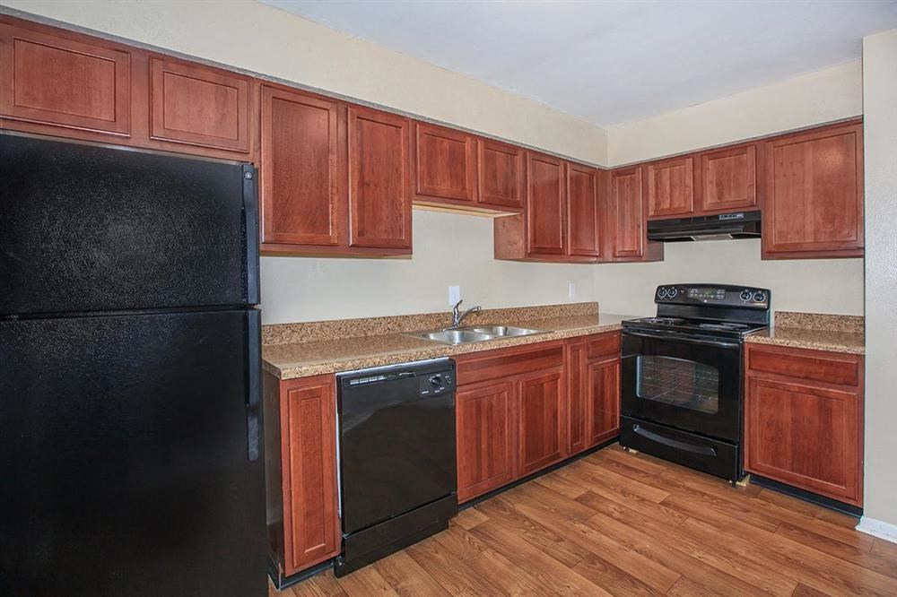 a kitchen with black appliances and wooden cabinets