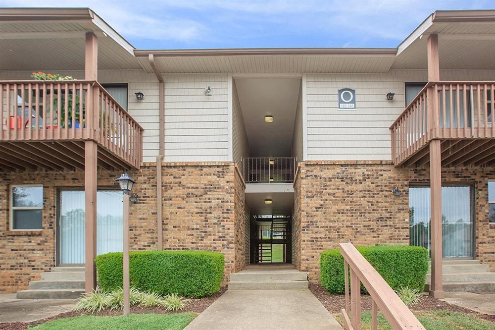 the front entrance of a building with a porch and stairs