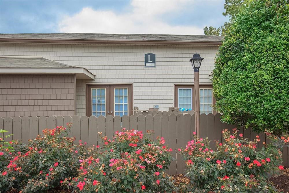 a house with a fence and some pink flowers