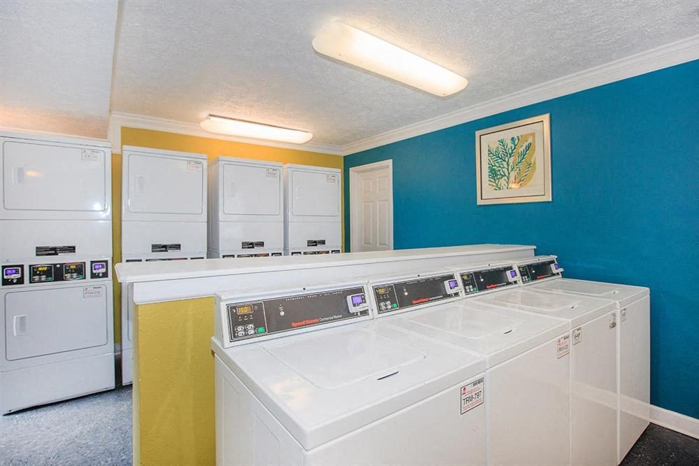 a laundry room with a row of white machines