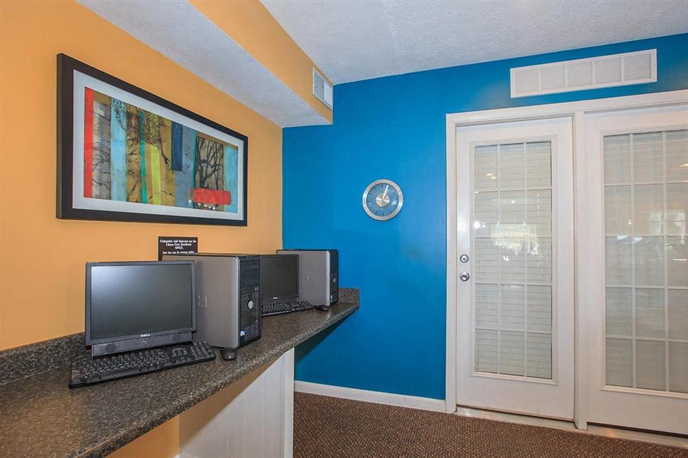 a room with a counter with computers and a door