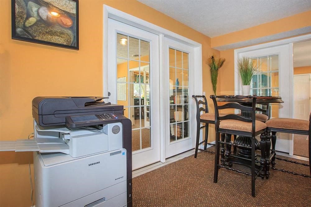 a room with a printer and a table with chairs